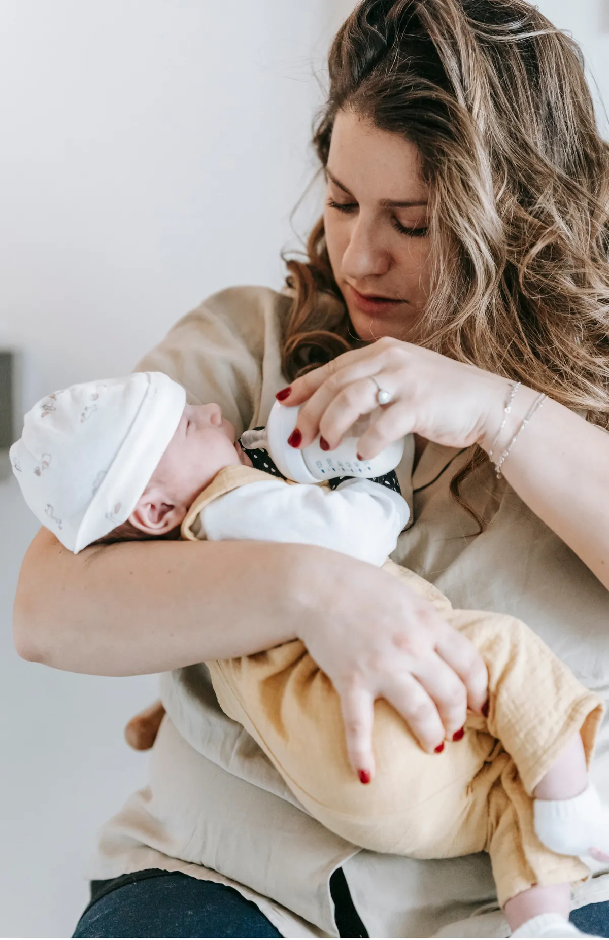 Stressed mum holding a crying baby refusing the bottle – bottle refusal support
